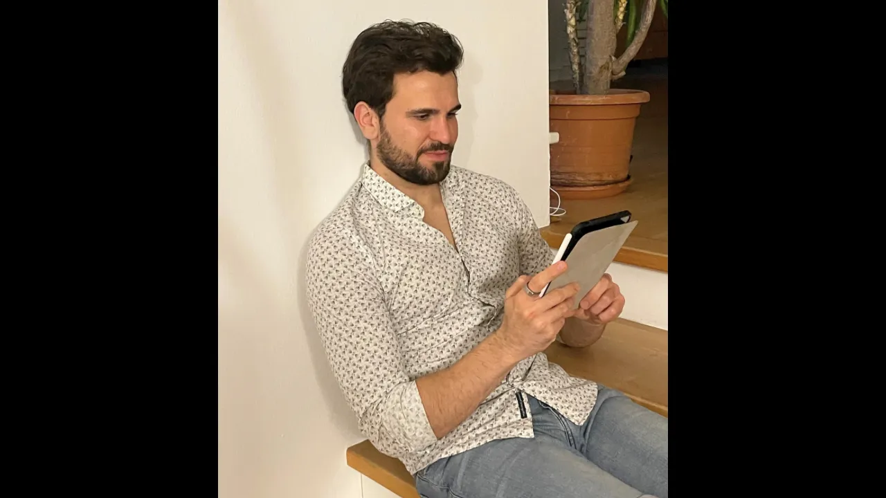 Man sitting indoors and reading on a phone