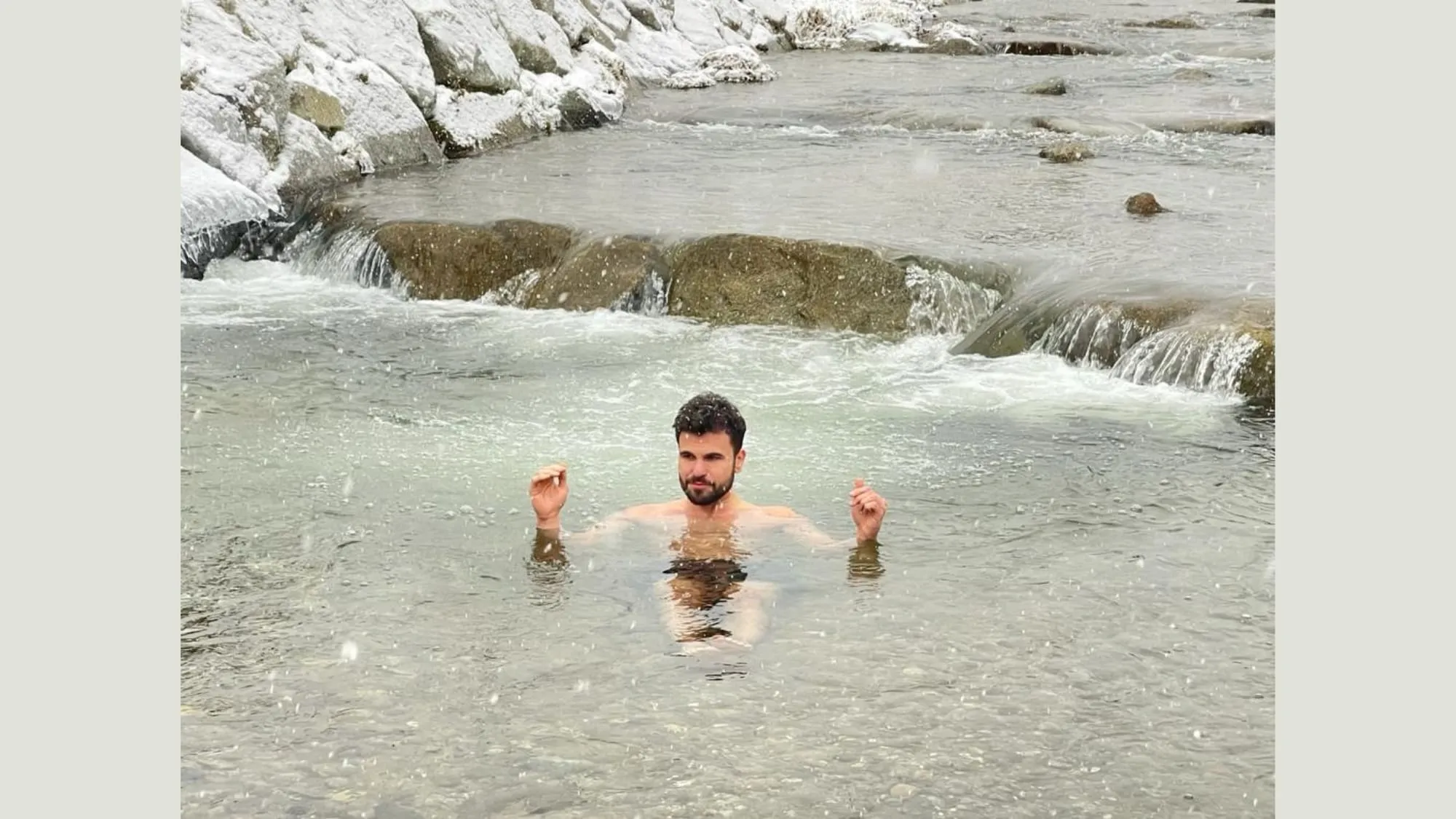 Person in outdoor ice bath with snow in background